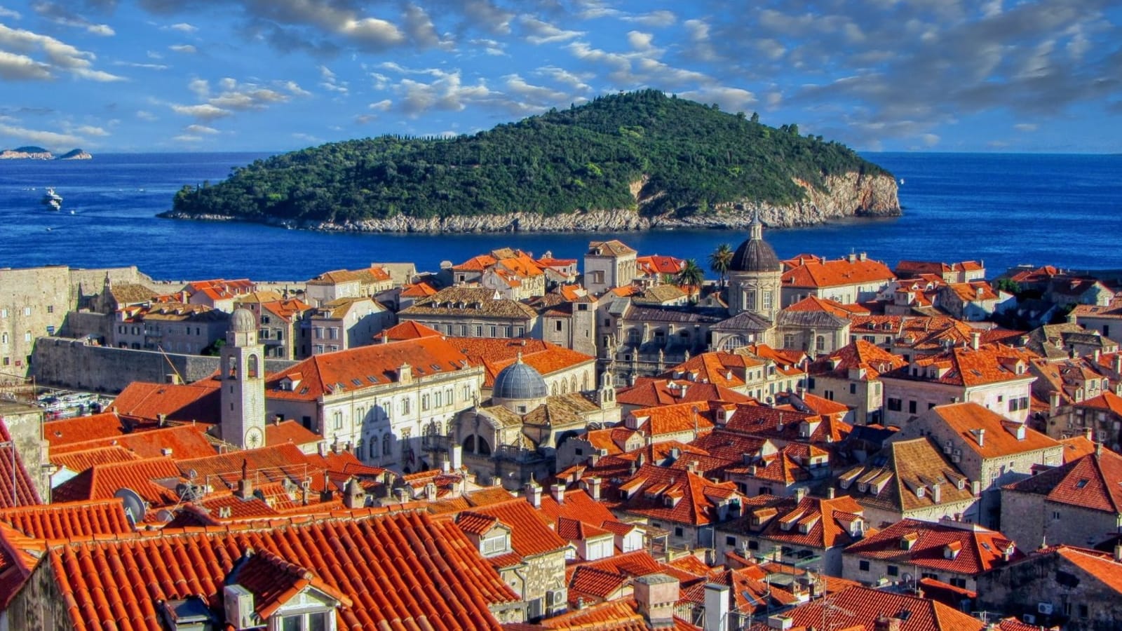 Terracotta rooftops of Dubrovnik old town with Lokrum island